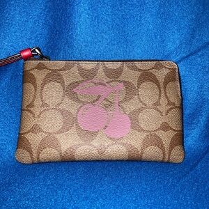 COACH CORNER ZIP WRISTLET IN SIGNATURE CANVAS WITH CHERRY MOTIF.